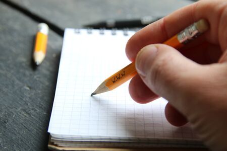 online education concept, hand holds a pencil with the inscriptionの写真素材