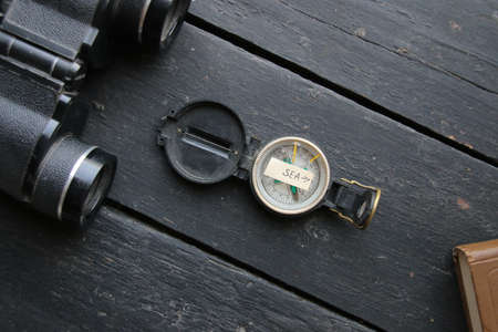 Pointer to the sea and an old compass. Summer vacation concept.の写真素材