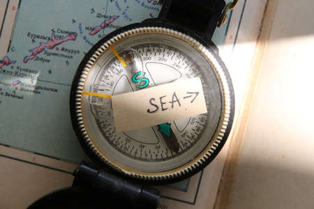 Pointer to the beach. Old compass and inscription.の写真素材