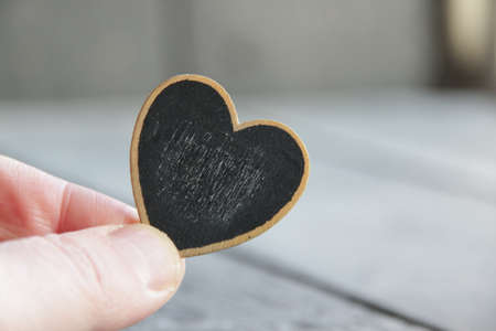 Valentine's day concept. Hand holds a heart-shaped tablet. Place for text.の写真素材