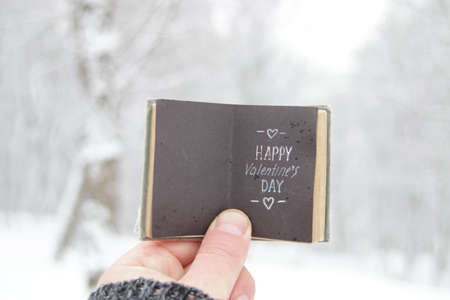 Happy valentines day. Hand holds a book with text.の写真素材