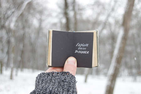 Explore dream discover. A hand holds a book with the inscription.の写真素材