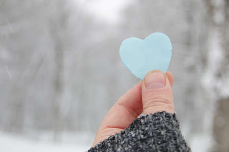Happy Valentine's day creative concept. Hand holds paper heart.の写真素材