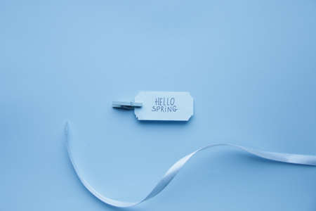 Hello Spring idea. lettering on a blue tag on a blue background.の写真素材