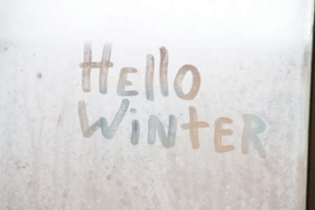 Hello winter text, winter background. The inscription on the frozen glass.の写真素材