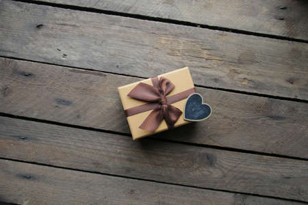 Vintage gift box with bow on an old table made of boards.の写真素材