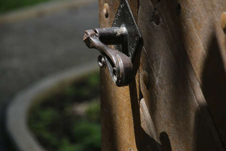 Open antique door, old wooden entrance door with antique door handle.の写真素材