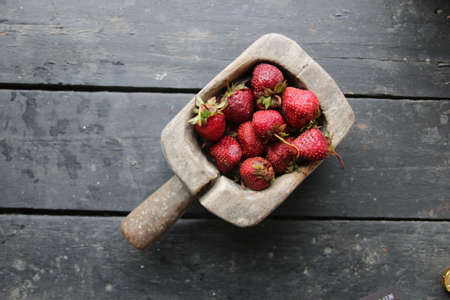 Fresh juicy strawberries in a wooden container.の写真素材