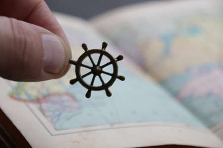Summer travel idea. Hand holds the smoll nautical steering wheelの写真素材