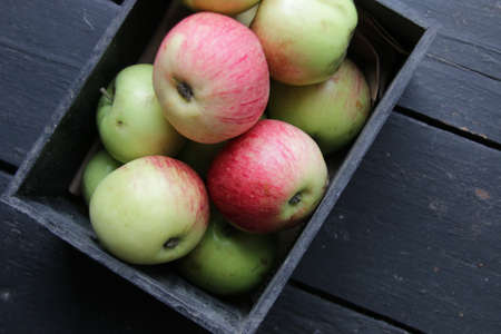 A box of fresh juicy apples on a vintage kitchen table.の写真素材