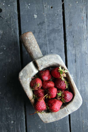 Fresh juicy strawberries in a vintage wooden container.の写真素材