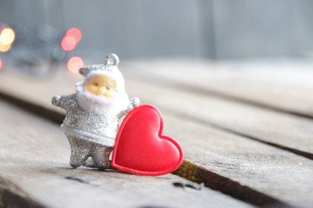 Santa Claus and red heart on the background of Christmas lights.の写真素材