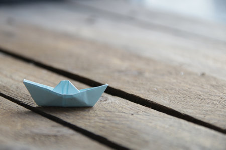Beautiful paper boat on a vintage wooden background.の写真素材