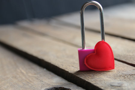 Padlock with a heart on a vintage wooden background.の写真素材