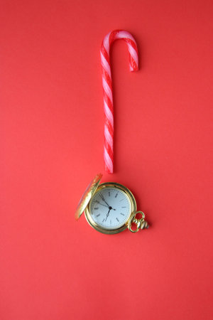 Merry Christmas creative card. Pocket watch and candy cane.