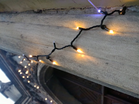 Christmas lights on a column of an old church. Merry christmas background.の写真素材