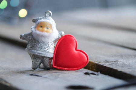 Santa Claus and red heart on the background of Christmas lights.の写真素材