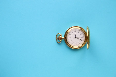 Golden retro pocket watch on a blue background.