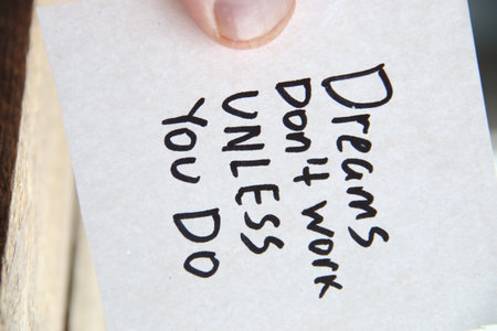 Motivational quotes inscription on a tag. Dreams don't work unless you do.