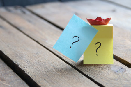 Large Question marks on cards on a wooden background.