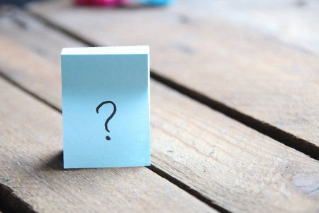 Large question mark on a wooden background..