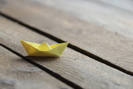 Beautiful paper boat on a vintage wooden background.の写真素材