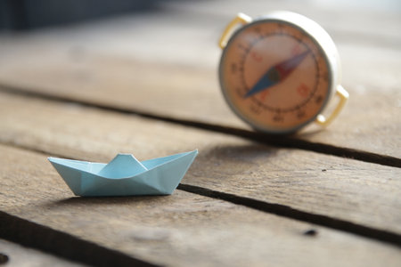 Beautiful paper boat on a vintage wooden background.の写真素材