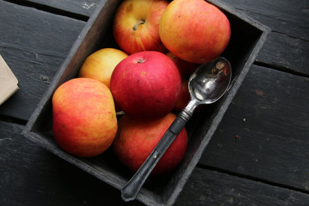 Ripe red apples in a wooden box. Red apples in a crate on rustic wood tableの写真素材