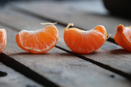 Slice of tangerine on old vintage table.の写真素材