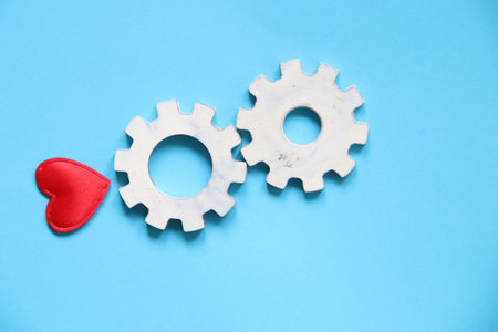 Gear wheels with heart symbol, blue background.の写真素材