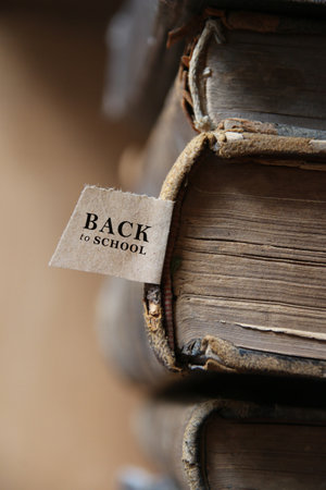 Back to school. Book and tag. Old books on a wooden shelf.の写真素材