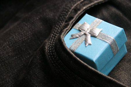 Blue Gift box in pocket of jeans.