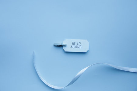 Hello Spring. The inscription on a blue label on a blue background.の写真素材