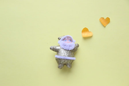Santa Claus on a yellow background with a hearts.