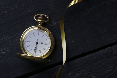 New Year`s Eve Concept. Gold pocket watch on vintage background.の写真素材