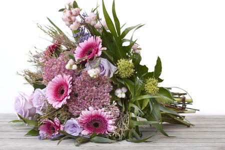 Beautiful bouquet of flowers lying on a wooden tableの写真素材