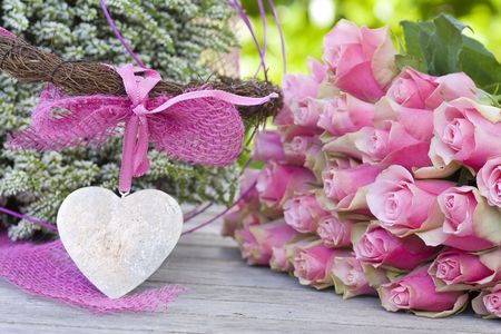 Beautiful roses with pink bow, heart and white heatherの写真素材