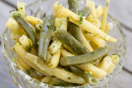 Bean salad of yellow and green beans in a glass bowl on a tableの写真素材