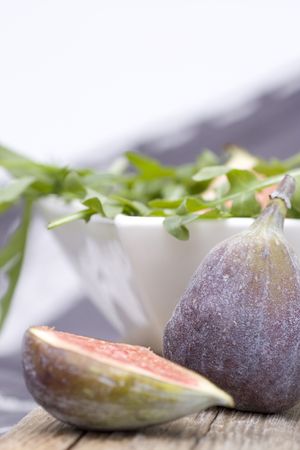 Figs with rocket salad on wood plateの写真素材