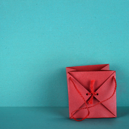 Gift bag in red, is isolated on a background in turquoiseの写真素材