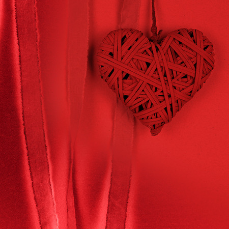 Braided heart on red background paperの写真素材
