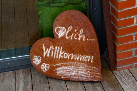 A sign in heart shape with the inscription welcomeの写真素材