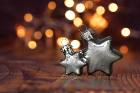 Silver Christmas tree stars in front of a festive backgroundの写真素材