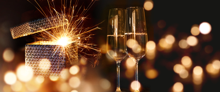 Sparkling New Year wishes with sparkling wine and golden lightsの写真素材