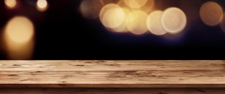 Dark panorama with golden light for public holidays in front of a empty wooden table for a concept