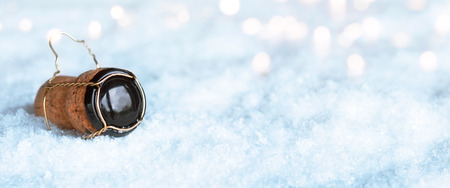 Panorama with champagne cork in the snow and bokeh for a conceptの写真素材