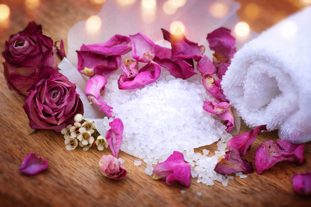 Spa still life with bath salt purple rose and a towel on a wooden tableの写真素材