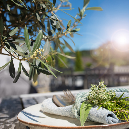 Mediterranean table decoration in summer on a terrace with sun and bokehの写真素材