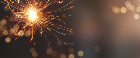Festive background with sparkling wonder candle and tender golden bokeh for christmasの写真素材