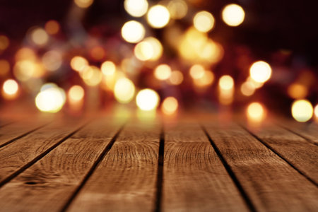 Festive background for christmas with golden bokeh and rustic wooden table for a decoration
